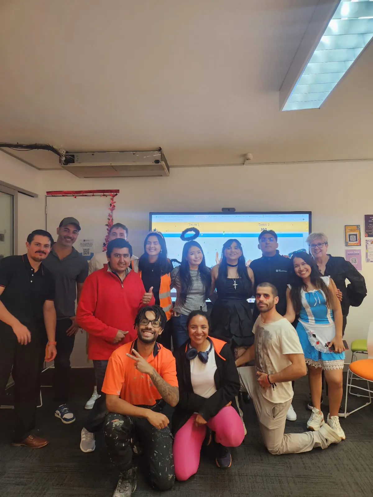 Whole class in costume, Halloween 2025 Boston Institute English class posing together in Halloween costumes in a classroom