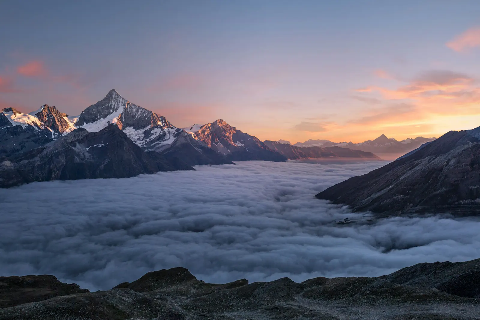 Mountains above the clouds Mountain peaks rising above a sea of clouds at sunset