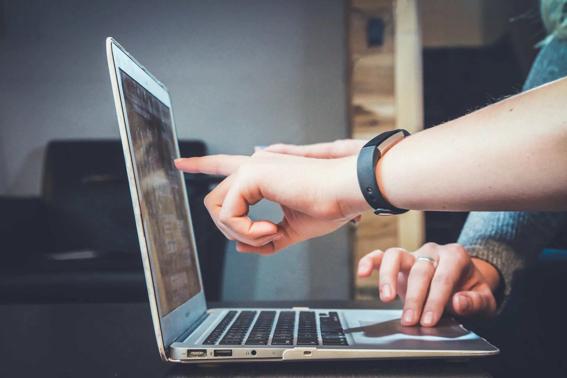 Working at a laptop Two people pointing at a laptop screen while working together