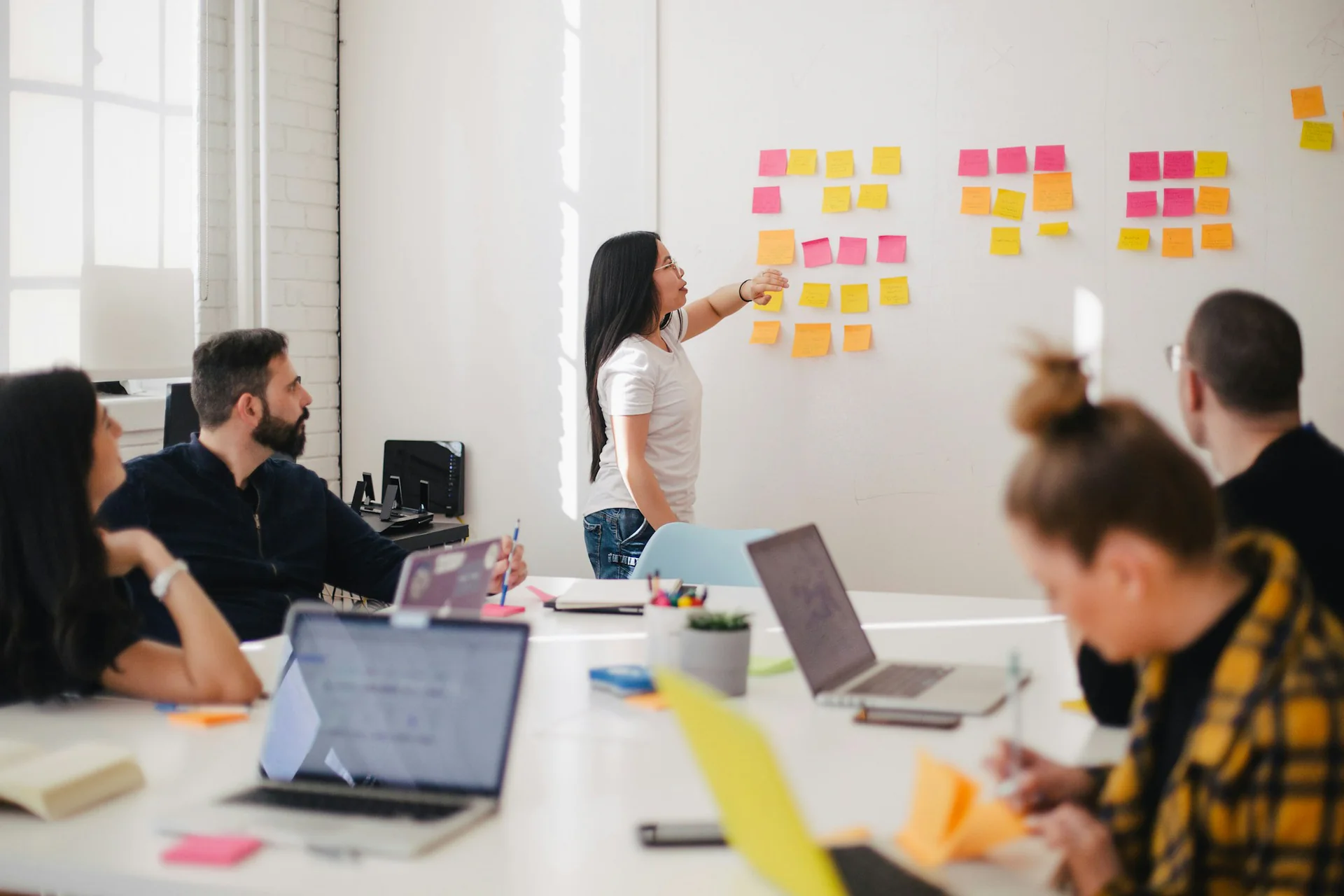 Team workshop Team collaborating in a workshop with sticky notes on a glass wall