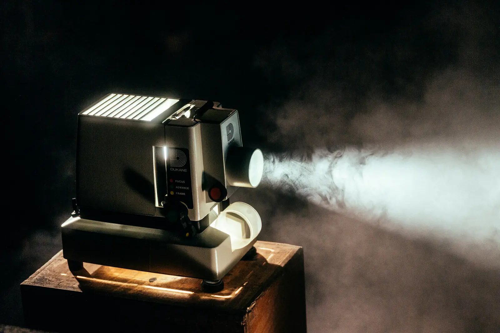 Film projector Vintage film projector casting a beam of light in a dark room