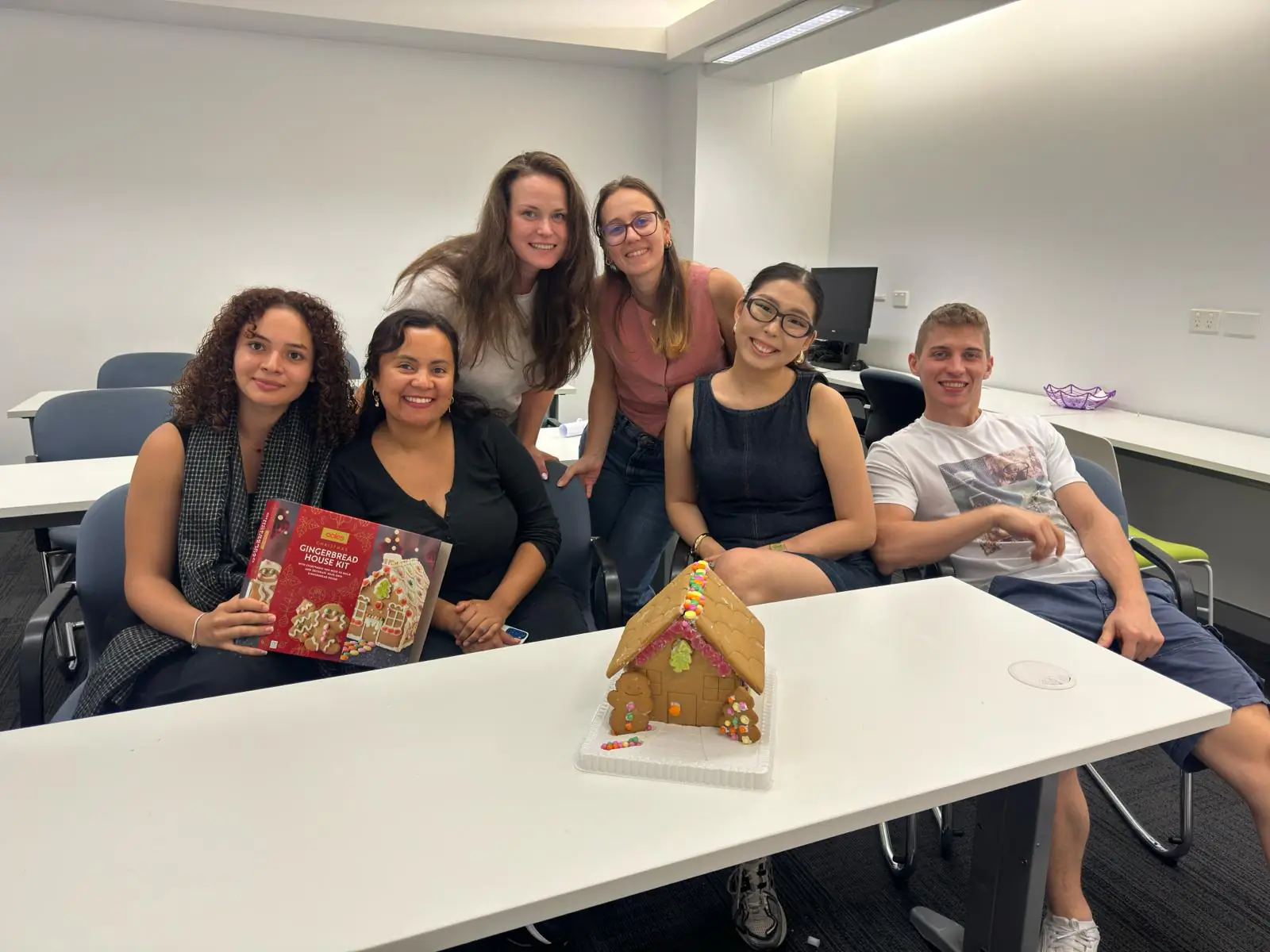 Gingerbread house team, Christmas 2025 Students with a gingerbread house kit at a Boston Institute Christmas class activity