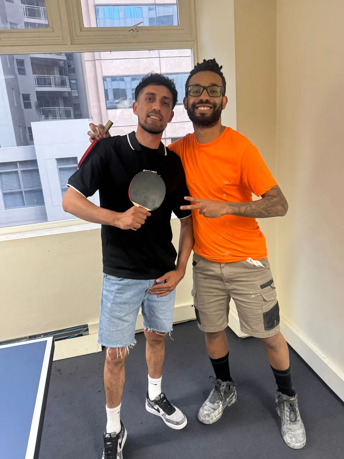 Table tennis partners, 2025 Two Boston Institute students holding table tennis bats before a match