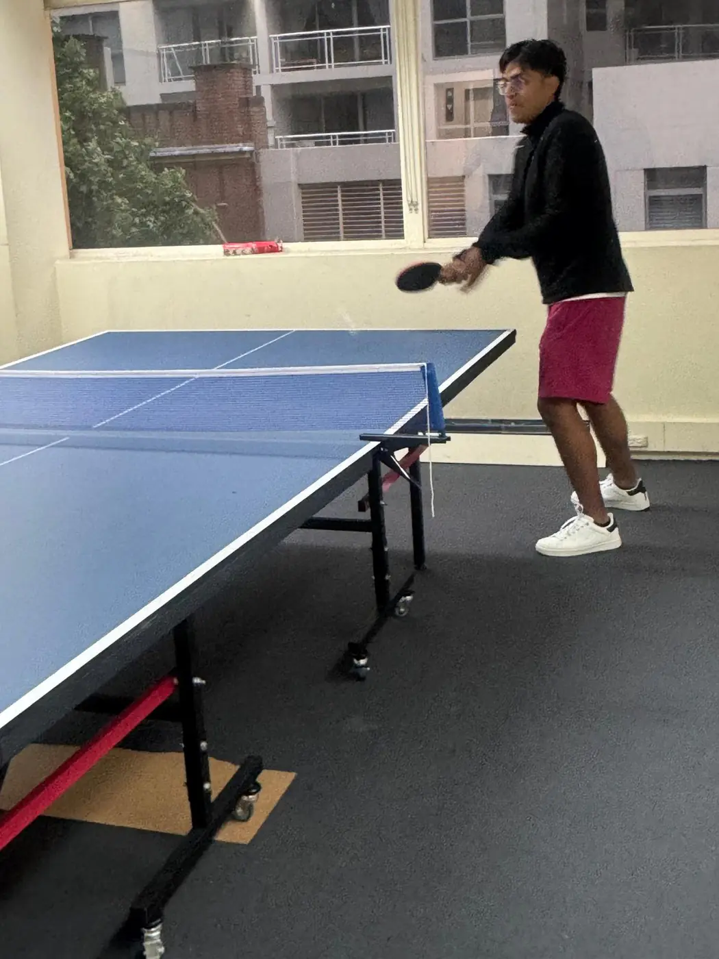 Table tennis rally, 2025 Boston Institute student rallying during a table tennis game