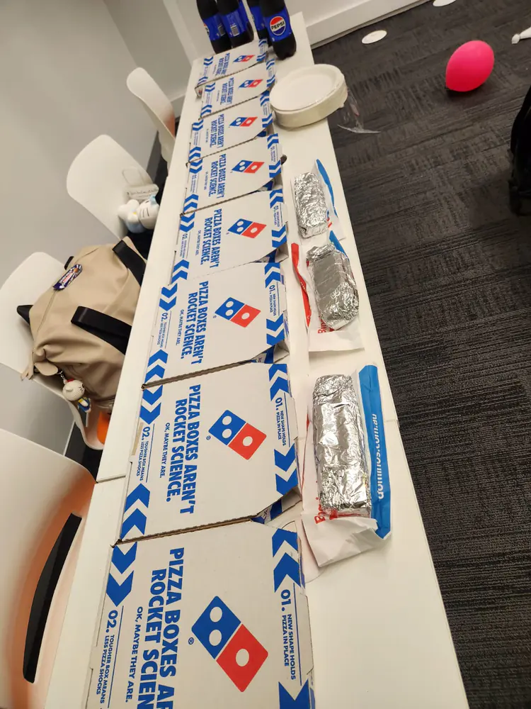 Halloween pizza spread, 2025 Halloween party table with stacked pizza boxes at the Boston Institute campus