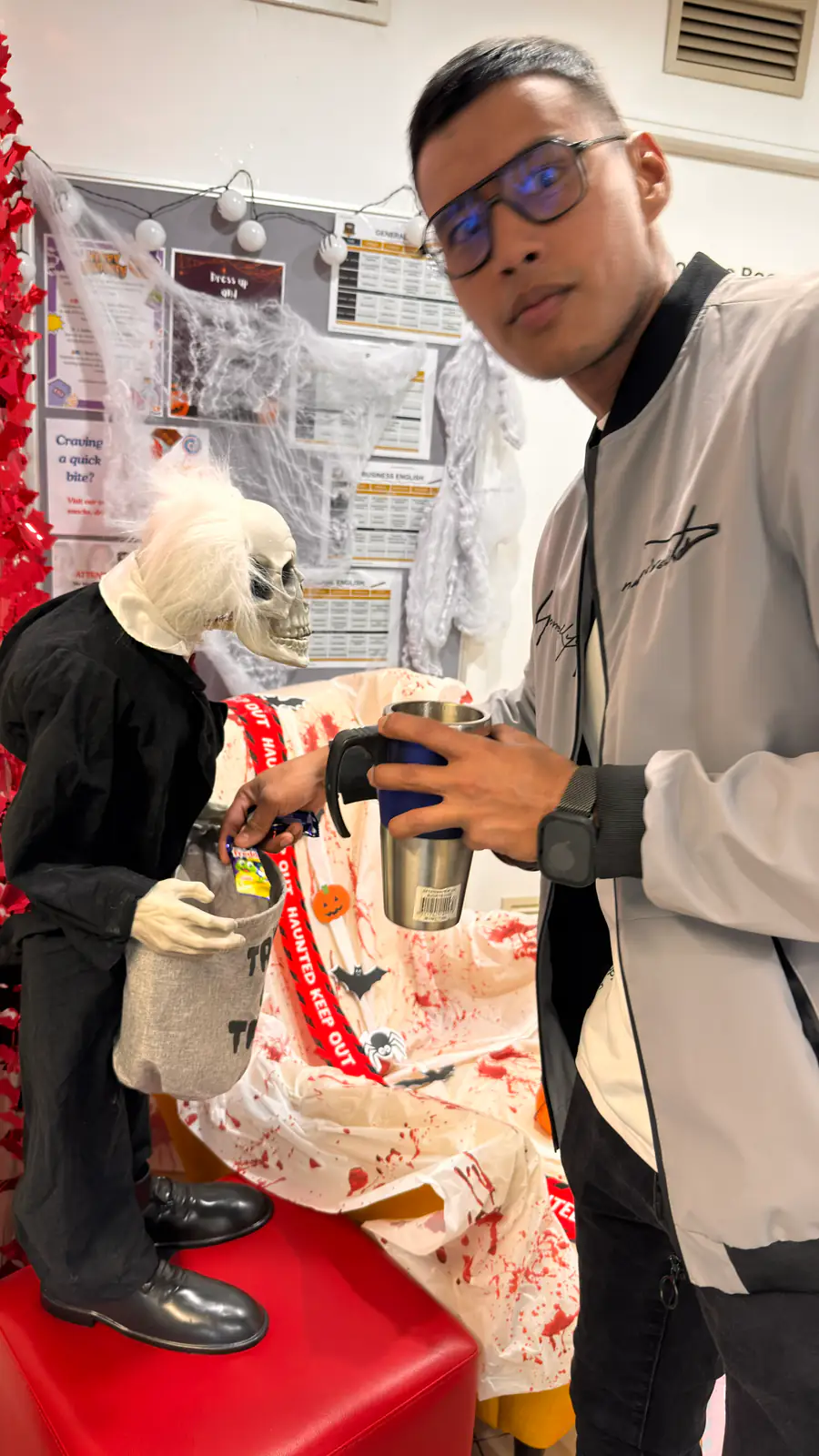 Skeleton decoration, Halloween 2025 Student standing beside a skeleton decoration at the Halloween party