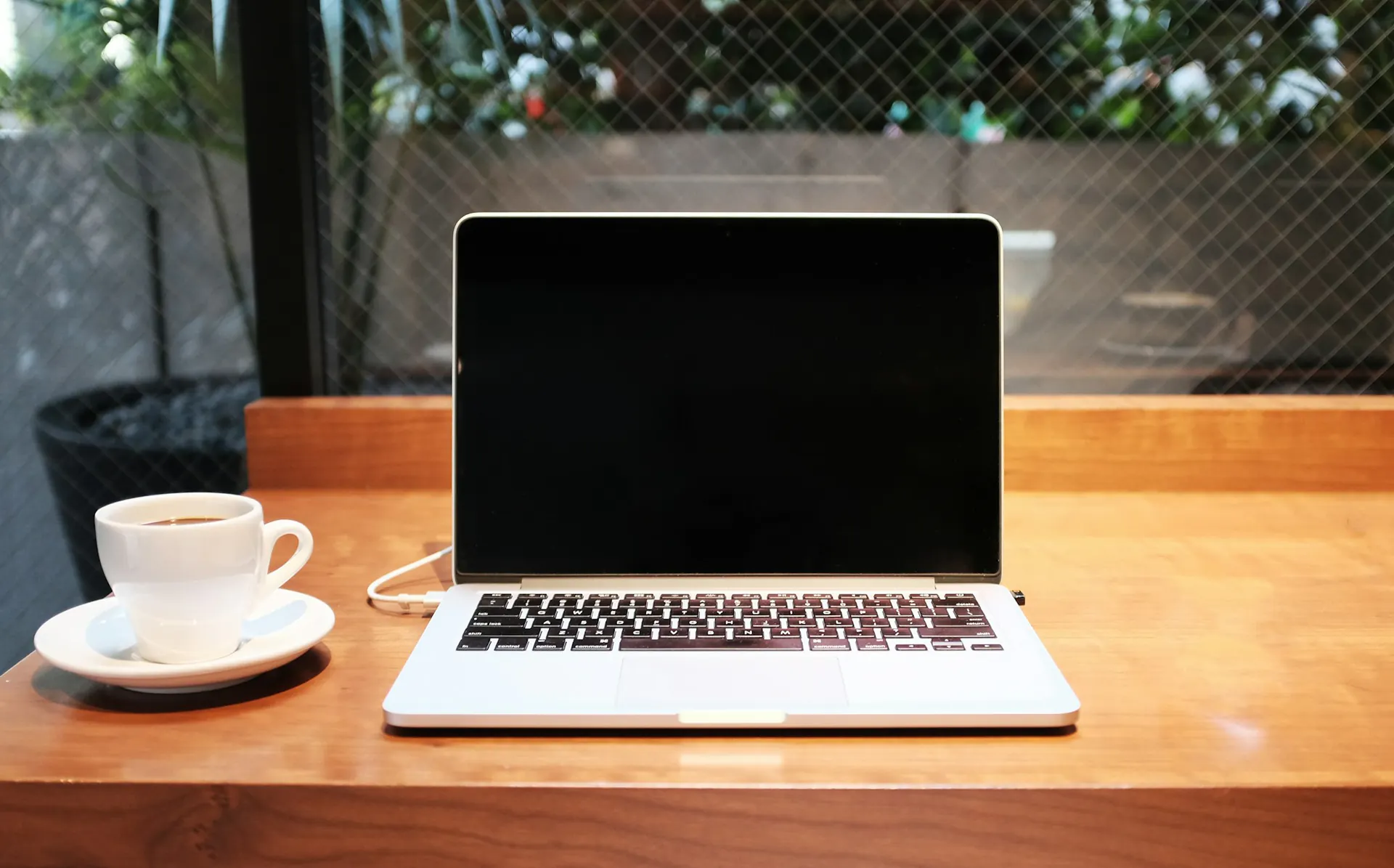 Laptop and cup of coffee set up for study on a wooden table